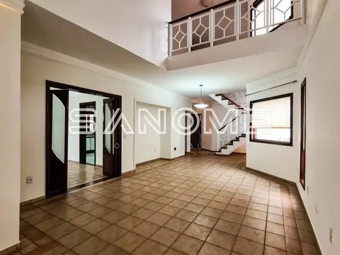 Sala ampla com piso em cerâmica e escada duplex