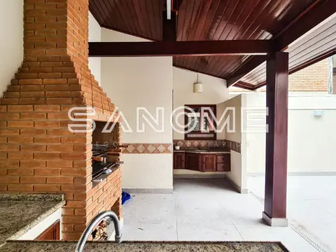 Área de serviço com churrasqueira de tijolos e cozinha