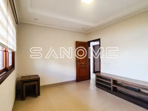 Sala vazia com duas portas de madeira e móvel de apoio