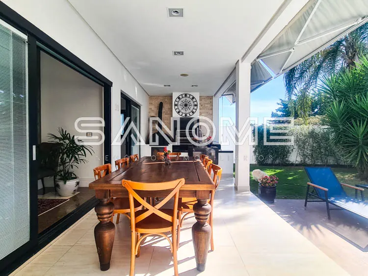 Sala de jantar com mesa de madeira e cadeiras estofadas