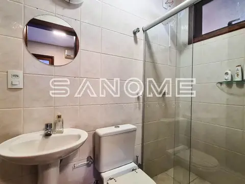 Banheiro com pia, vaso sanitário e box de vidro