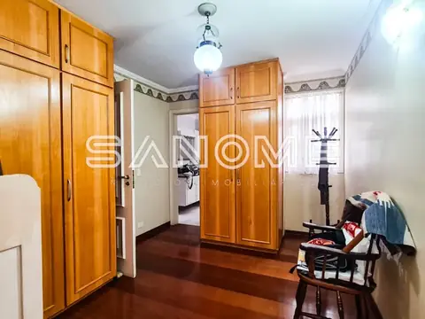 Quarto com guarda-roupas de madeira e piso em tacos