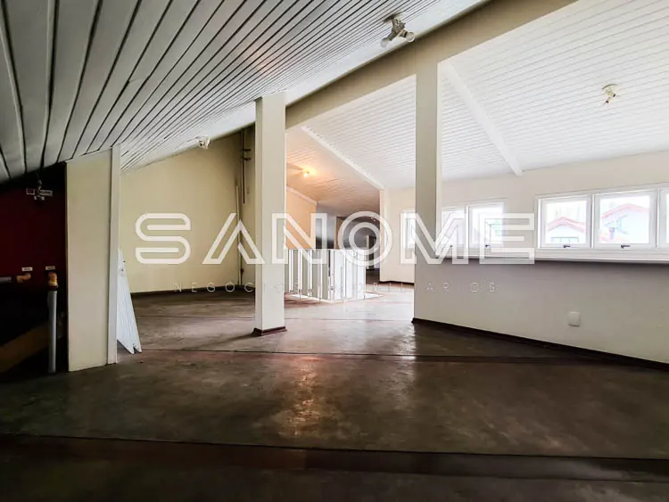 Sala ampla com piso cinza e colunas de sustentação
