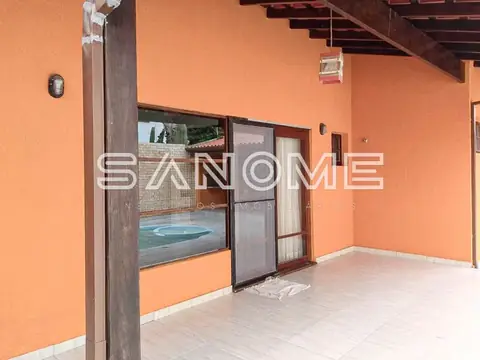 Varanda com parede laranja e vista para piscina