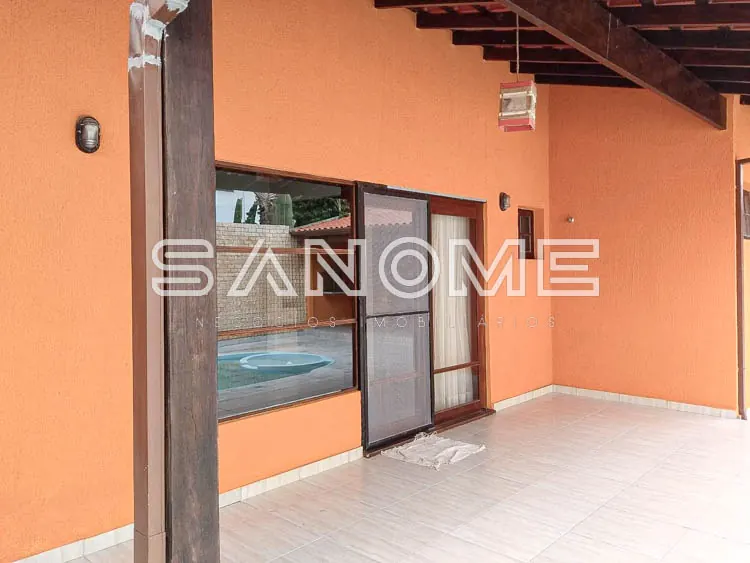 Varanda com parede laranja e vista para piscina