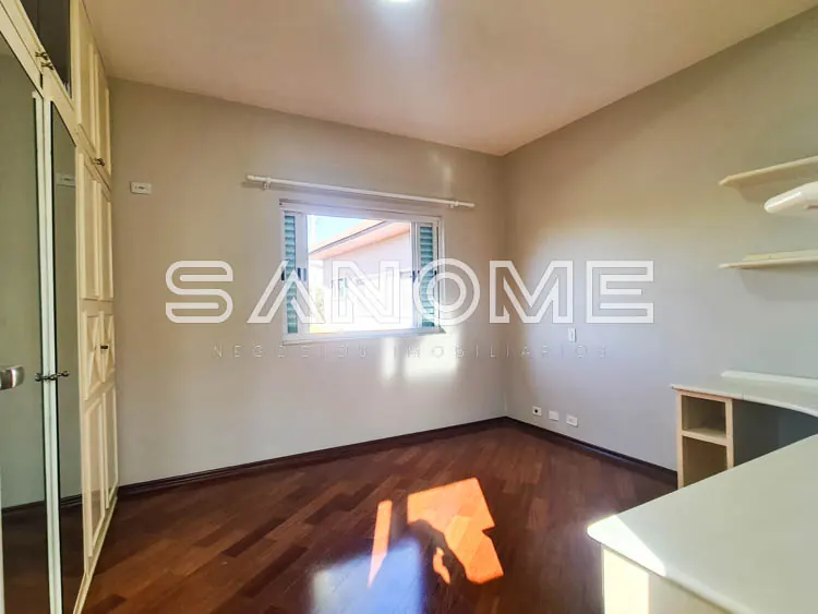 Quarto com piso de madeira e janela com vista