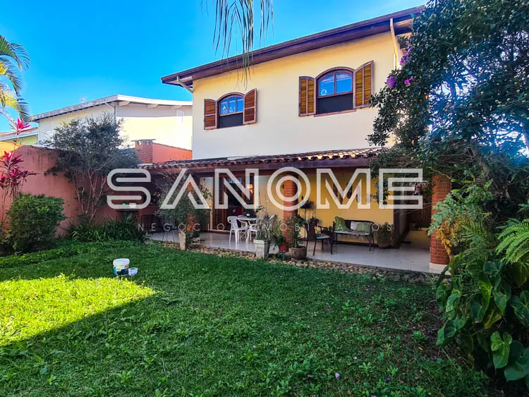 Casa com fachada clara e área externa gramada