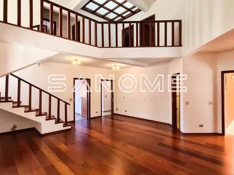 Sala ampla com escada e mezanino em madeira