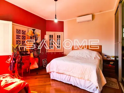 Quarto com cama de casal e paredes vermelhas e laranja