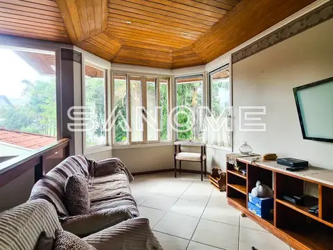 Sala de estar com sofá, móvel suspenso e janelas amplas
