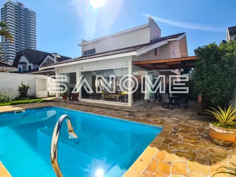 Área externa com piscina e casa ao fundo