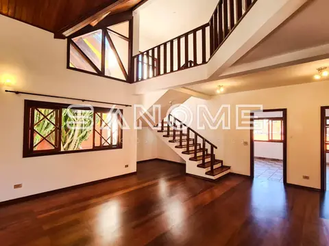 Sala ampla com escada e piso de madeira