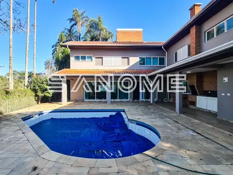Área externa com piscina e casa ao fundo