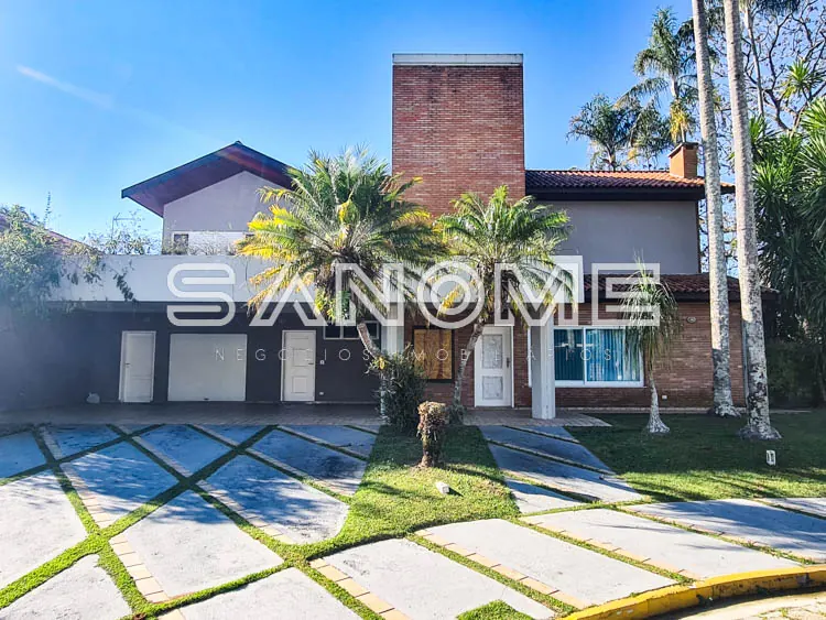 Fachada de casa com garagem e torre de tijolos