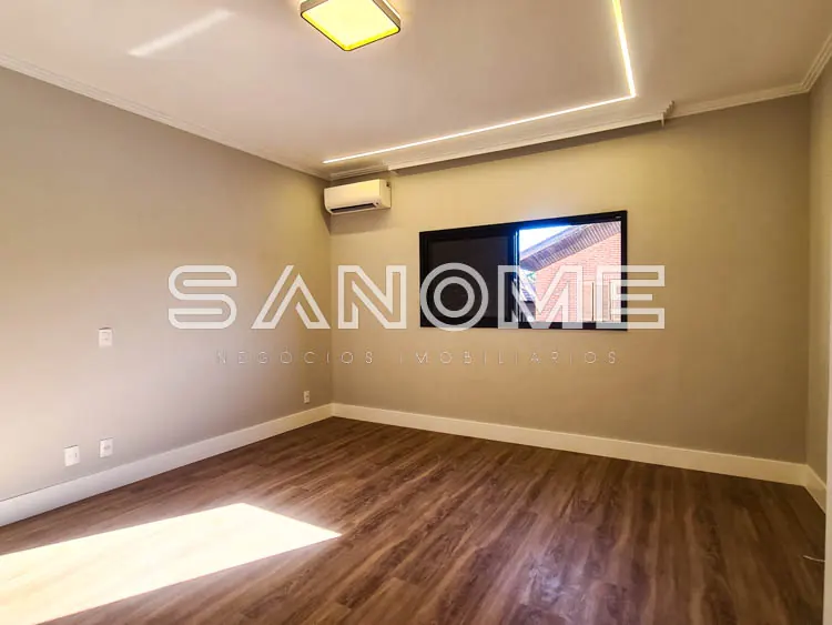 Sala vazia com piso de madeira e parede bege