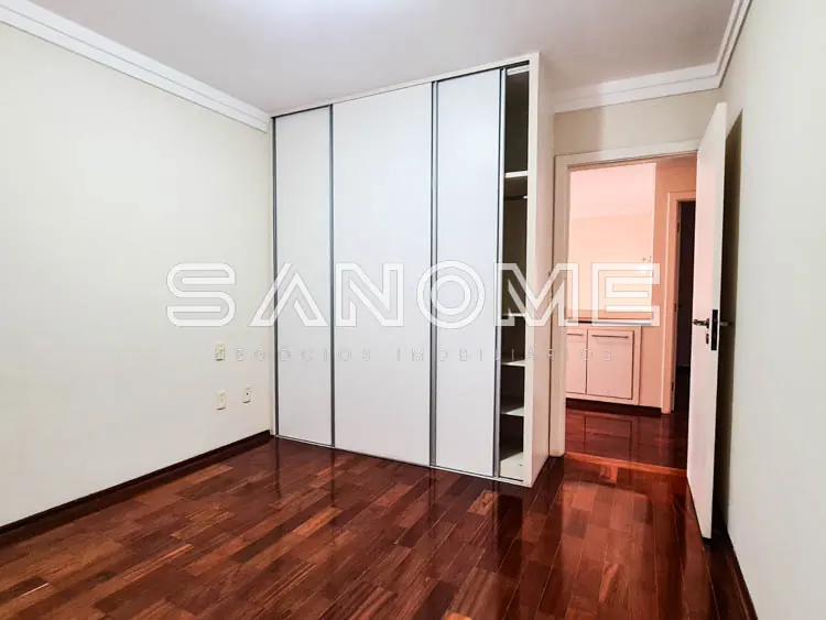 Quarto com guarda-roupa embutido e piso em madeira