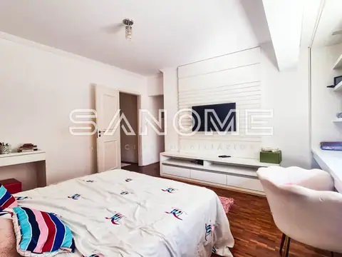 Quarto com cama de casal e painel de TV