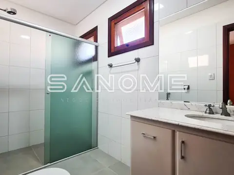 Banheiro com chuveiro box verde e pia de mármore