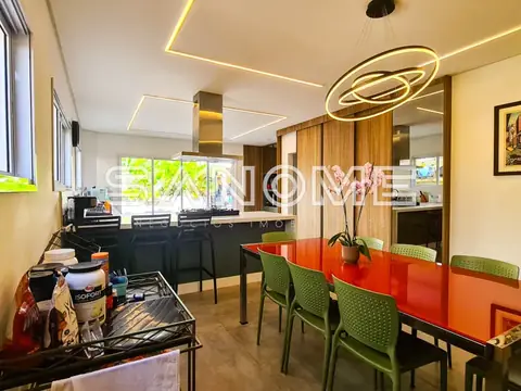 Cozinha integrada com mesa vermelha e cadeiras verdes