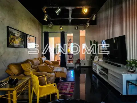 Sala de estar com sofá amarelo e painel de TV