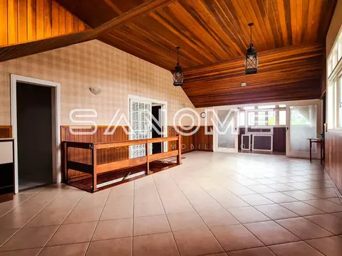 Salão amplo com teto de madeira e piso cerâmico