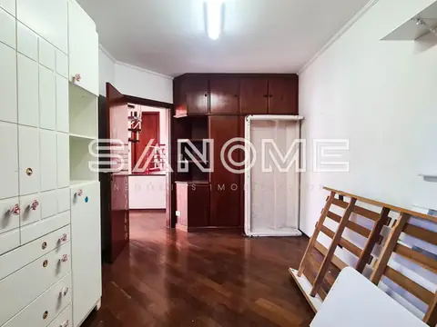 Cozinha com armários vermelhos e piso escuro