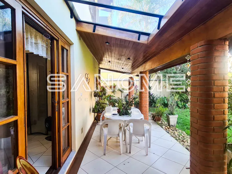 Varanda coberta com mesa, cadeiras e plantas
