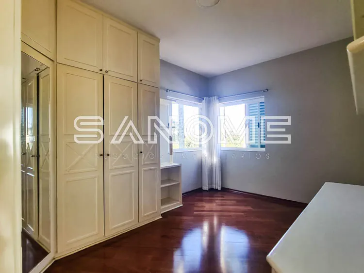 Quarto com guarda-roupa planejado e piso de madeira