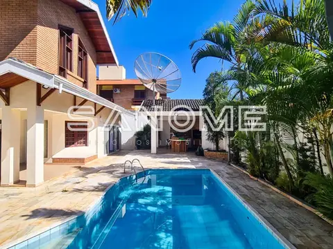 Área externa com piscina e casa ao fundo