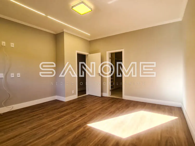Sala ampla com portas, piso de madeira e iluminação natural