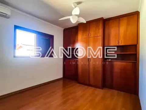 Quarto com guarda-roupa de madeira e piso de taco