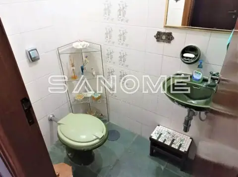 Banheiro com vaso sanitário e pia verde