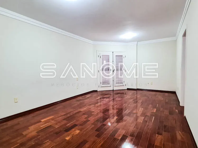 Sala vazia com piso de madeira e portas brancas