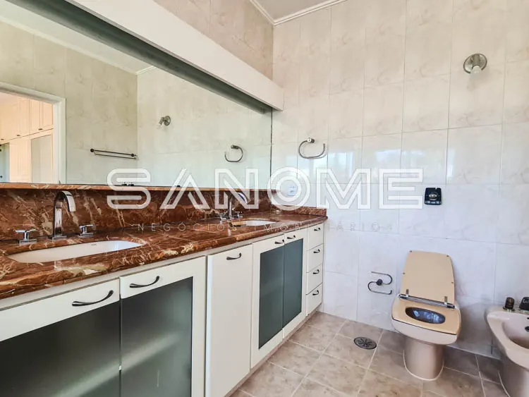 Cozinha com bancada de mármore e armários brancos