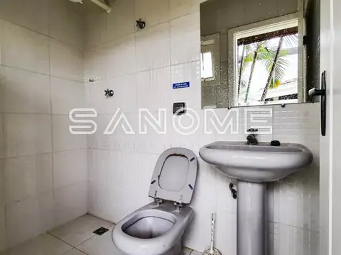 Banheiro com vaso sanitário e pia de pedestal