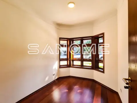 Sala com piso de madeira e janelas com vista externa