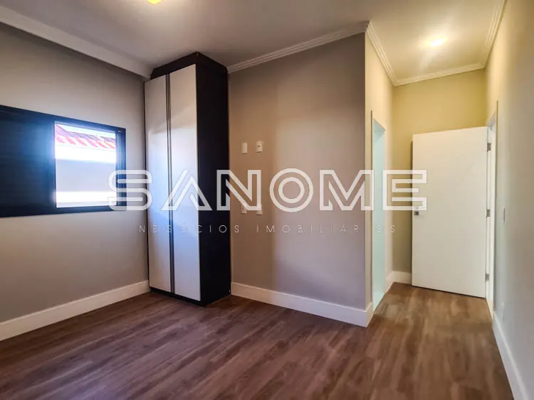 Quarto com guarda-roupa espelhado e piso de madeira