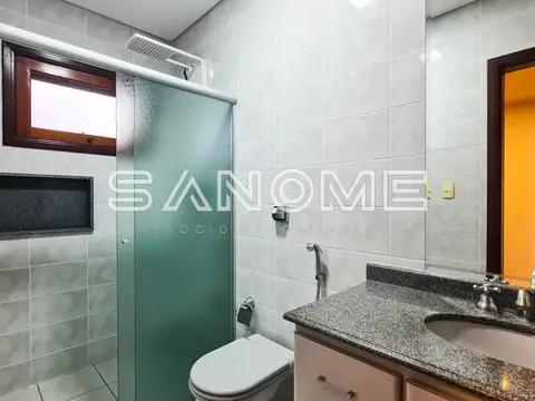 Banheiro com pia, vaso sanitário e box com porta verde