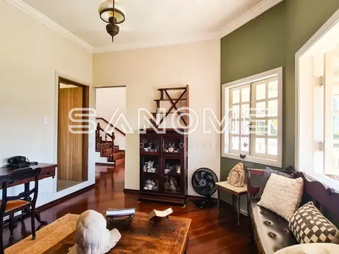 Sala de estar com sofá, móvel preto e piso de madeira