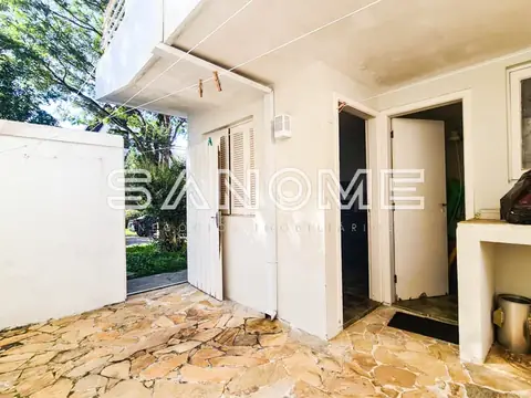Área externa com piso em pedra e portas de acesso