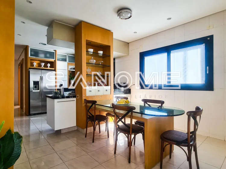 Cozinha e sala de jantar integradas com móveis em tons quentes